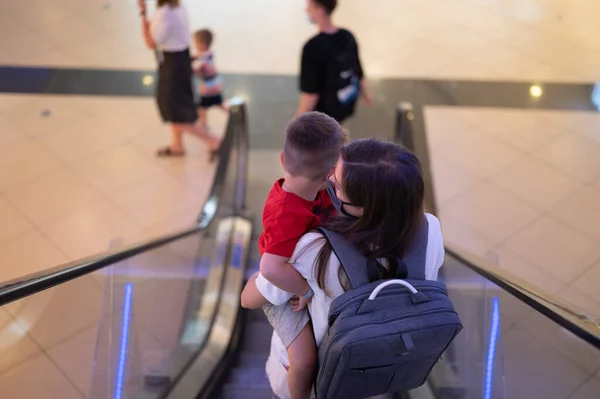 Maman Avec Enfant Dans Les Bras Descendre Sur Escalier Roulant Photos De Stock Libres De Droits