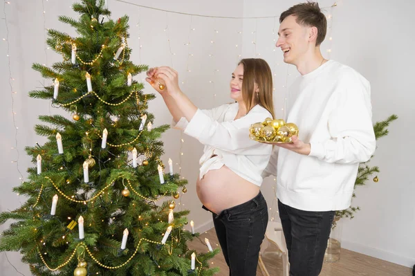 Giovane Donna Incinta Che Decora Albero Natale Con Suo Marito — Foto Stock