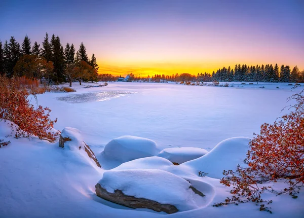 Winter landscape scene with a frozen lake. Winter at the park. This JPG winter landscape stock photo is suitable for projects that involve lakes, winter scenery,  park, trees and the holiday season. Great image for greetings cards and postcards. 