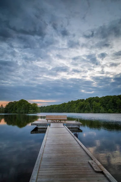 Tahta köprü, İsveç 'te sakin bir göl kenarındaki platforma açılıyor.