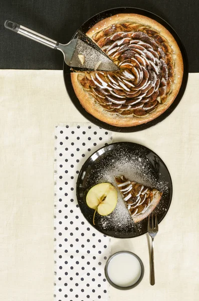 Apple pie with cinnamon and sugar on black plate — Stock Photo, Image