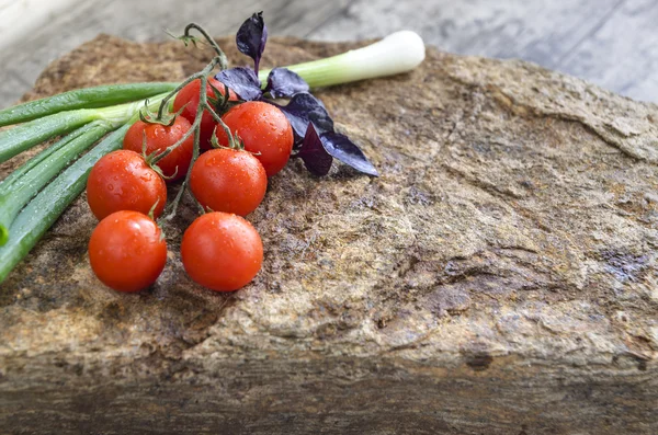 Fresh vegetables: cherry tomatoes, onion and basil on a stone — Stock Photo, Image