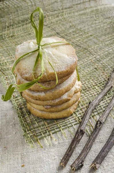 Pile of lemon sugar cookies tied up with rope and dried branches, blurred background — Stock Photo, Image