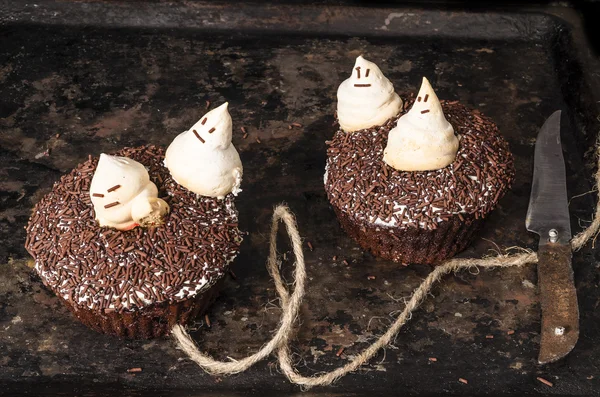 Two chocolate pumpkin cupcakes, decorated with meringue ghosts Stock Picture