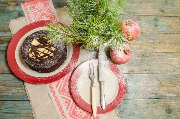 Stillleben mit Schokoladenkuchen, Weihnachtsbaum und Granatapfel — Stockfoto