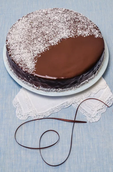 Festivee tårta med choklad glasyr på bordet serveras med vit porslin — Stockfoto