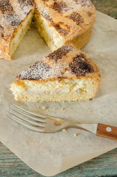 Stuk van Napolitaanse Pasen cake en forrk op inpakpapier — Stockfoto