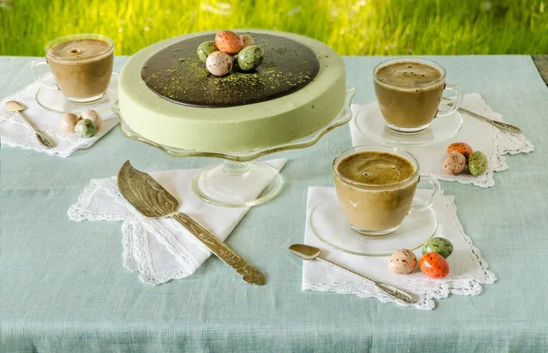 Mesa de Pascua con té matcha cheesecake y café blanco sobre fondo de hierba verde —  Fotos de Stock