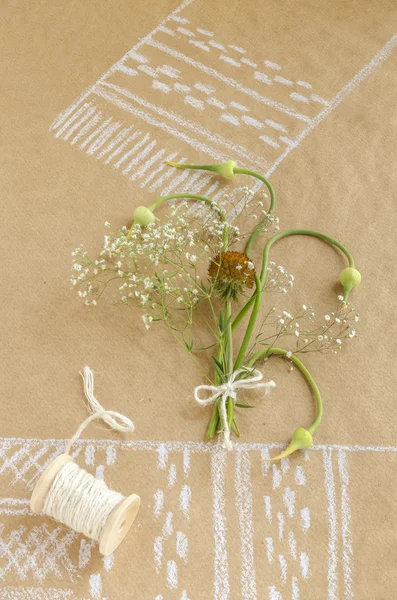 Nature morte avec ail, bourgeons, fleurs et bobine de ficelle — Photo