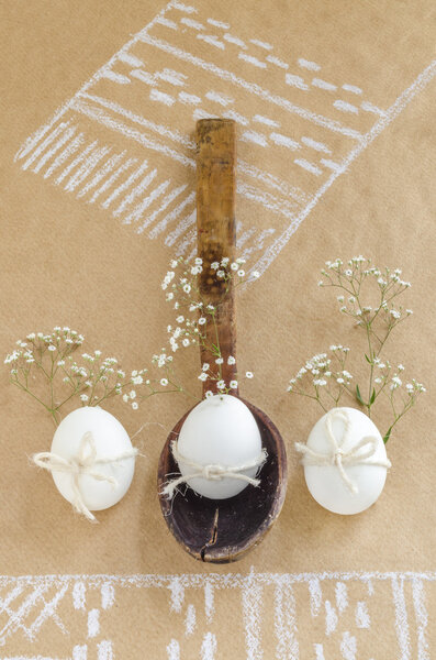 Easter still life with old wooden spoon, eggs and flowers.