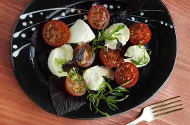 Ingradients İtalyan caprese salatası ile taze fesleğen yaprakları, domates ve mozzarella kırmızı ahşap tablo