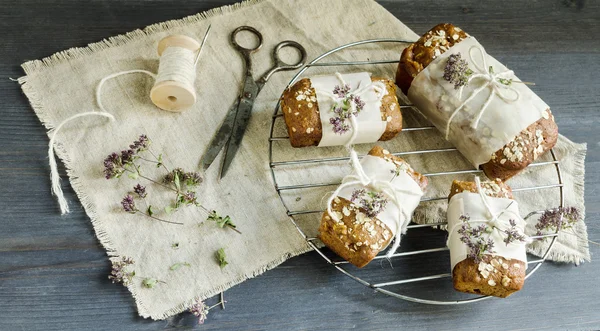 Homemade bread with apples in wrapping paper on grid — Stock Photo, Image