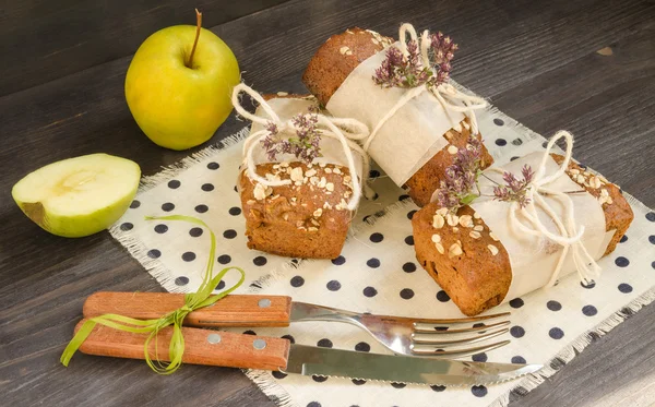 Pain fait maison aux pommes en papier d'emballage et pomme sur lin — Photo