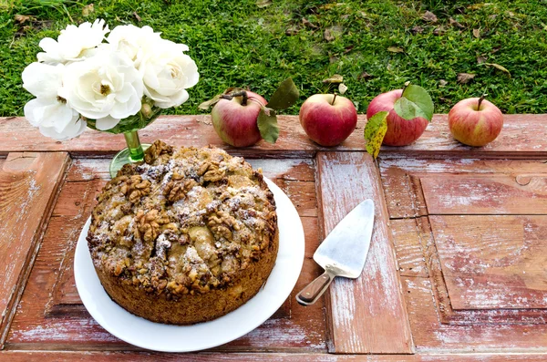 Outono ainda vida com bolo, nozes, maçãs e rosas brancas. Estilo rústico . — Fotografia de Stock