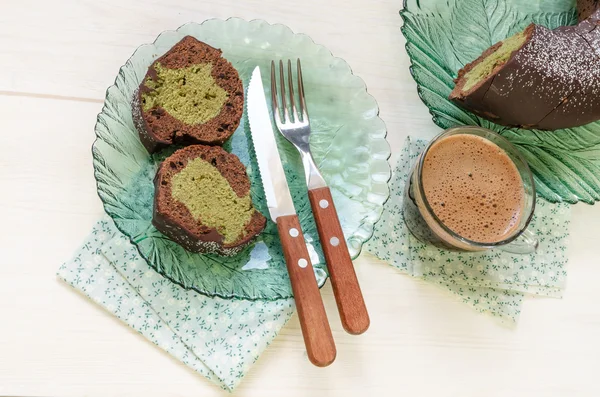 Deux tranches de gâteau et une tasse de café noir sur fond de bois blanc . — Photo