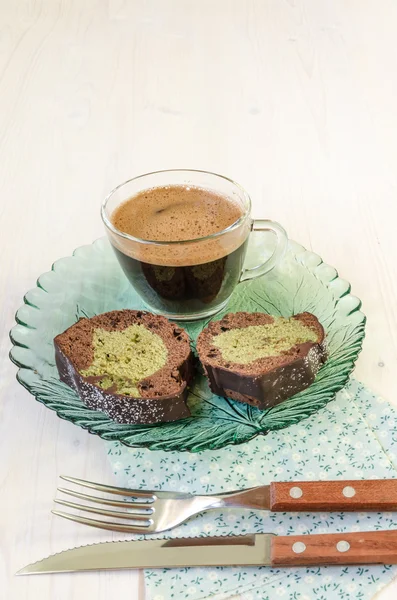 Zwei Scheiben Kuchen und eine Tasse schwarzen Kaffee auf weißem Holzhintergrund. — Stockfoto