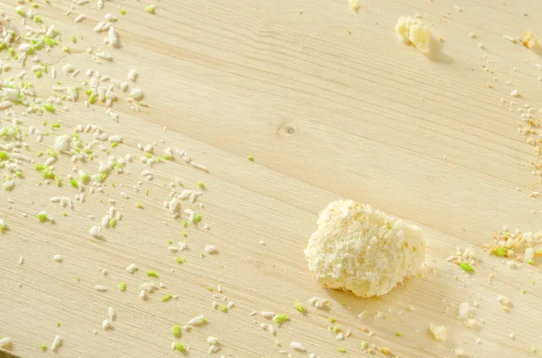 Witte houten achtergrond met suiker cookie kruimels en vlokken kokosnoot — Stockfoto