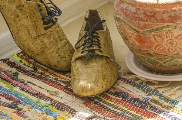 Bodegón con zapatos de hombre, maceta y alfombra tejida — Foto de Stock