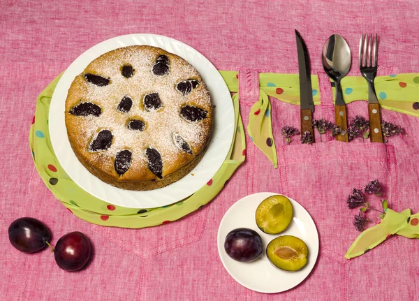 自制蛋糕, 粉红桌布上有李子。静物. — 图库照片