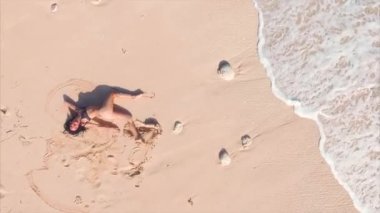 Genç ve çekici bir kadın kumsalda dinleniyor. 