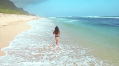 Genç ve çekici bir kadın kumsalda dinleniyor. 