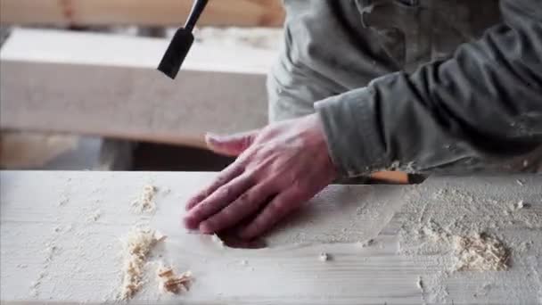 Un falegname unidintified sta lavorando con attenzione con scalpello nella sua officina — Video Stock