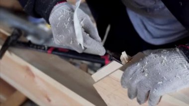 Kimliği belirsiz bir marangoz atölyesinde keskiyle çalışıyor.