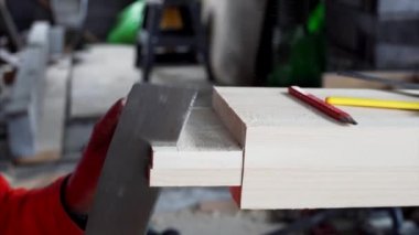 Kimliği belirsiz bir marangoz atölyesinde keskiyle çalışıyor.