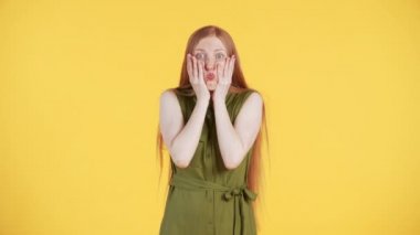 Çilli ve uzun kızıl saçlı genç bir kadın kameraya bakıyor ve 