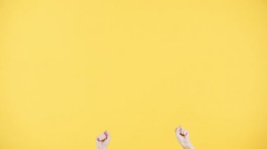 Çilli bir kadın çerçevede beliriyor, hayret içinde cama vuruyormuş gibi yapıyor, gülümsüyor ve birine el sallıyor. Sarı arkaplan