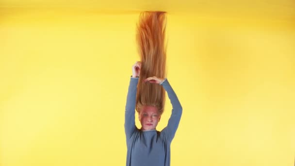 Kafasının Üstünde Uzun Kızıl Saçlı Bir Kadın Kameraya Bakıyor Saçlarını — Stok video