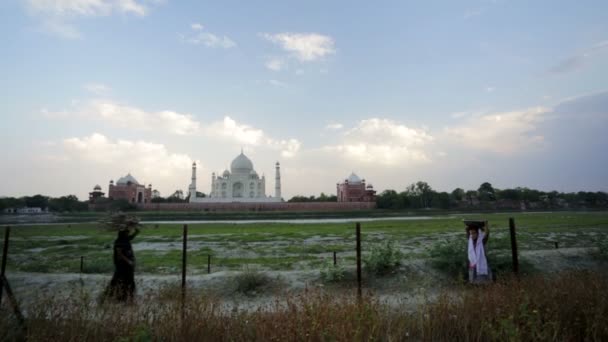 Människor på en bakgrund av Taj Mahal — Stockvideo