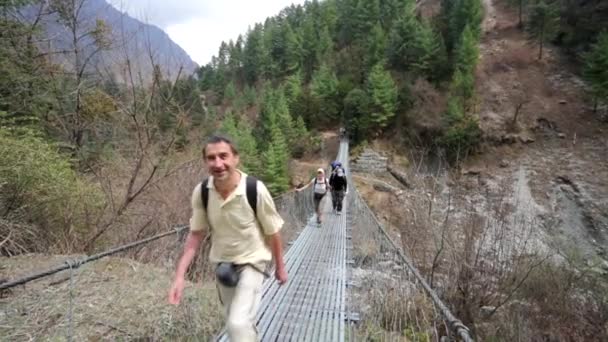 Trekkers cruzan puente — Vídeo de stock