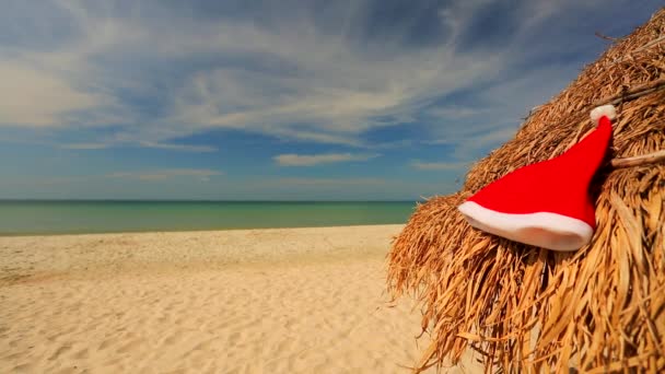 Santa hat laying on straw umbrella — Stock Video