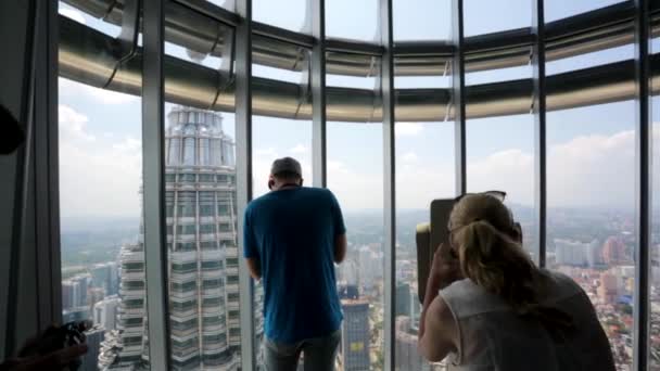 Touristen besuchen Petronas Zwillingstürme — Stockvideo