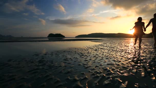 Couple courant sur une plage au coucher du soleil — Video