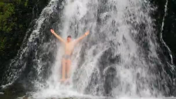 Чоловік купається у водоспаді — стокове відео