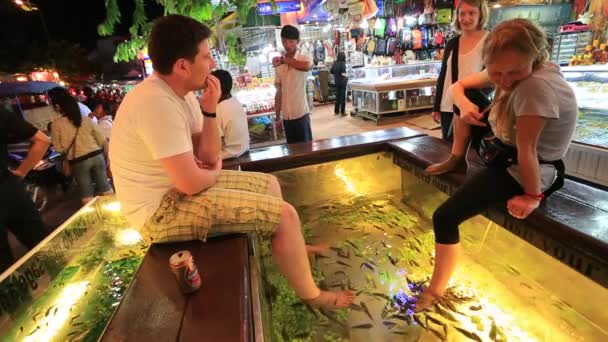 Люди любят рыбный массаж ног — стоковое видео