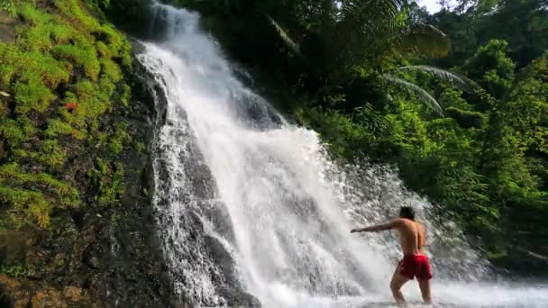 Чоловік купається у водоспаді — стокове відео