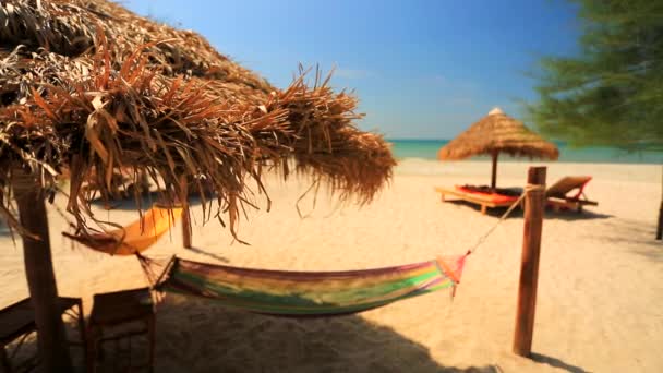 Hamacas bajo sombrilla de paja en la playa — Vídeo de stock