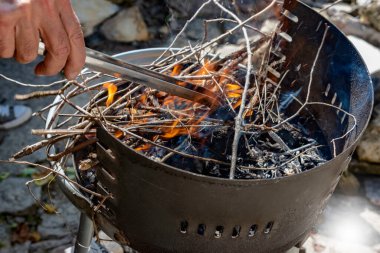 Yanan dalları olan bir Brezilyalı. Rostil için ateş, yanan odun