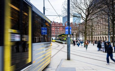 18 Şubat 2026 'da St. Peters Meydanı' nın işlek kentsel ortamından geçen bulanık bir Metrolink tramvayı görüntüleyen yaratıcı bir çekim..