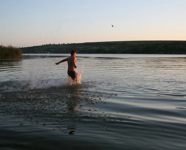 若い男が夜に川で浴びる — ストック写真