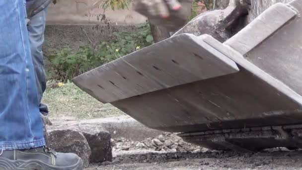İşçiler yol yüzeyinden kazıcı kovasına granit taşlar yüklüyorlar. — Stok video