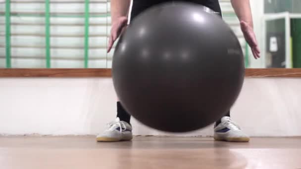 Muž ve fitness třídě s velkým nafukovacím míčem — Stock video