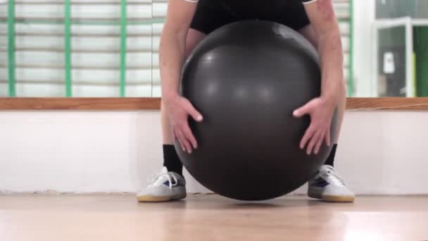 Людина в фітнес-класі з великим надувним м'ячем — стокове відео