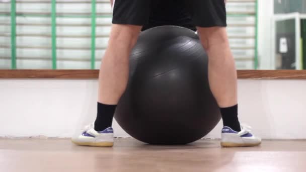 팽창할 수있는 커다란 공을 가진 건강 반에 있는 남자 — 비디오