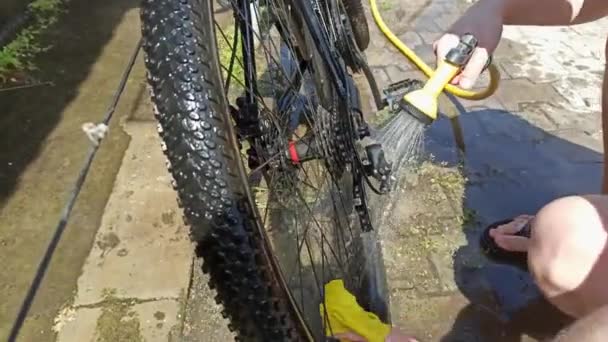 Homem Lava Bicicleta Com Pano Com Água Uma Mangueira Imagens — Vídeo de Stock