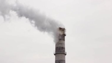 Sanayi bölgesinde büyük bir boru. Kazan dairesi işi. Kalın beyaz duman gökyüzüne taşar. Çevre kirliliği