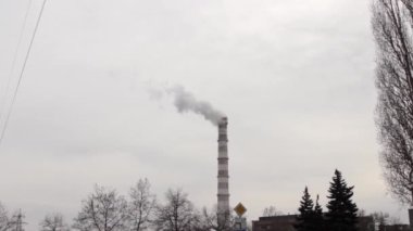 Sanayi bölgesinde büyük bir boru. Kazan dairesi işi. Kalın beyaz duman gökyüzüne taşar. Çevre kirliliği